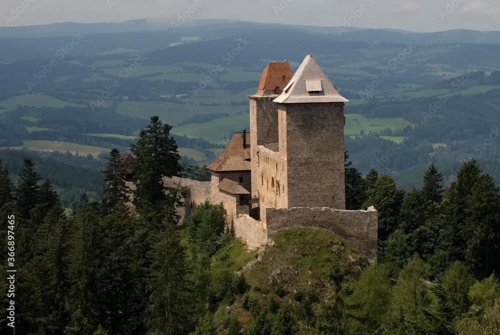 old castle on a hill, in the background a landscape with forests