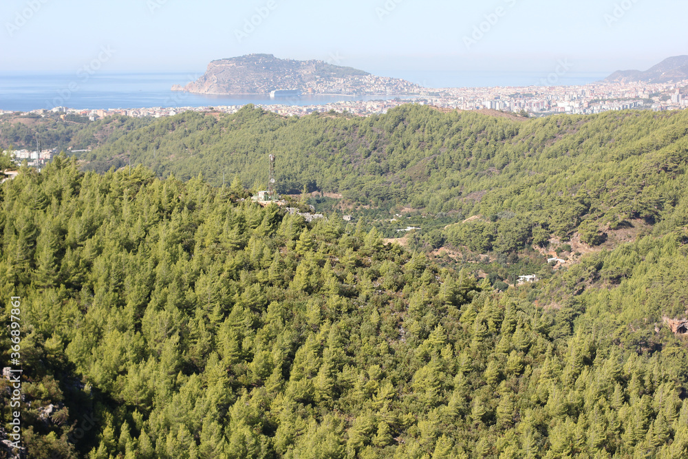 Naklejka premium Alanya, TURKEY - August 10, 2013: Travel to Turkey. Helene Hills. Mountains in the background in the distance. Rocks, wildlife of Turkey. Forest and clear blue sky.