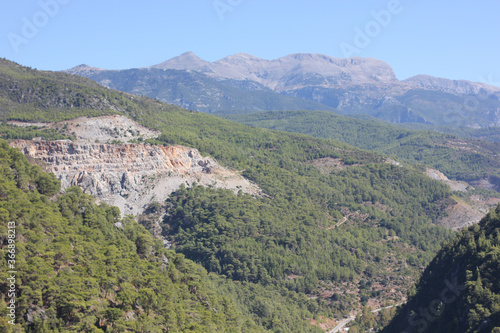 Alanya, TURKEY - August 10, 2013: Travel to Turkey. Helene Hills. Mountains in the background in the distance. Rocks, wildlife of Turkey. Forest and clear blue sky. © andreswestrum