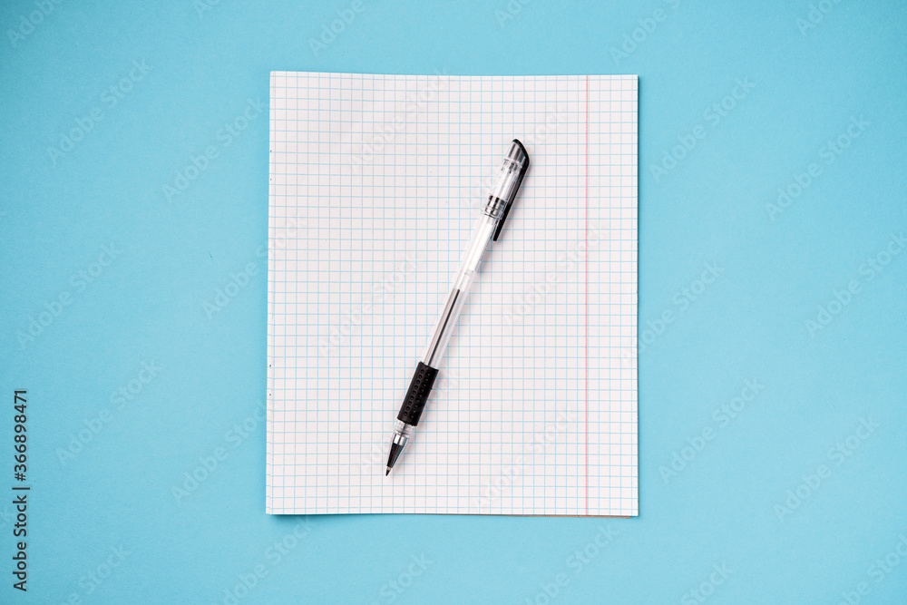 Top view of blank school paper with pen on blue background Top view of blank school paper with pen on blue background