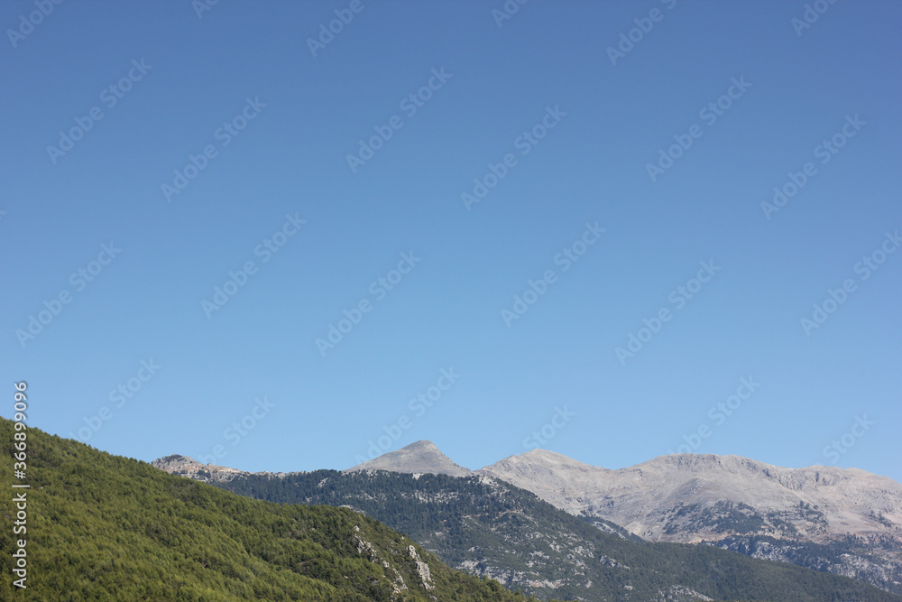 Alanya, TURKEY - August 10, 2013: Travel to Turkey. Helene Hills. Mountains in the background in the distance. Rocks, wildlife of Turkey. Forest and clear blue sky.