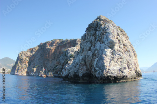 Alanya, TURKEY - August 10, 2013: Travel to Turkey. The waves of the Mediterranean Sea. Water surface. Mountains and hills on the coast of Turkey. Port. Green hills. © andreswestrum