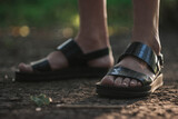 a girl walks through the forest alone, female legs close-up. Young girl in sandals