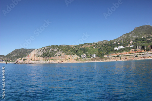 Alanya, TURKEY - August 10, 2013: Travel to Turkey. The waves of the Mediterranean Sea. Water surface. Mountains and hills on the coast of Turkey. Green hills. Port. © andreswestrum