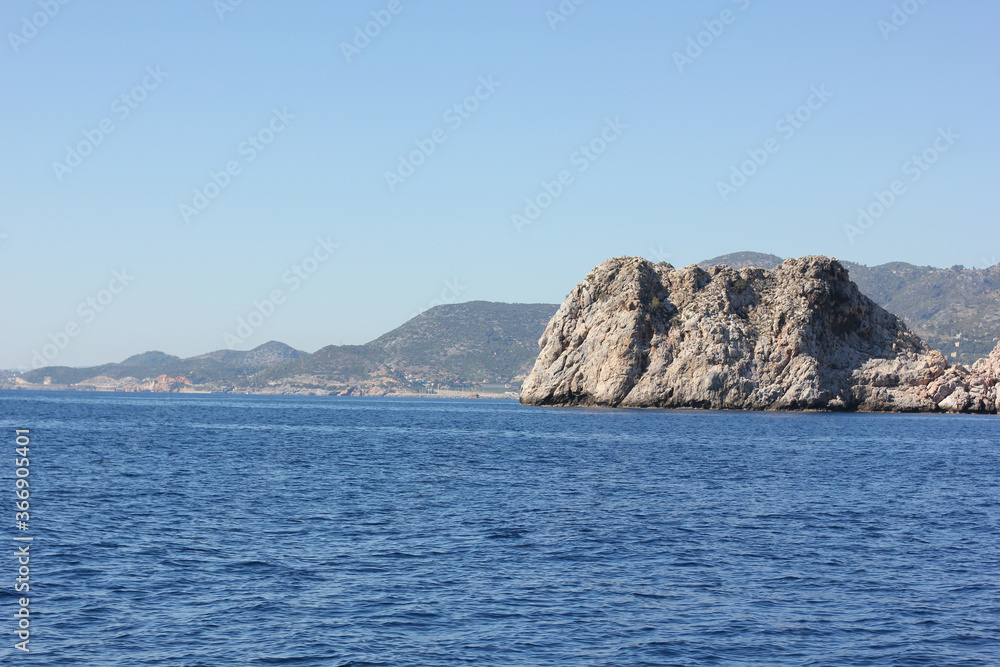Alanya, TURKEY - August 10, 2013: Travel to Turkey. The waves of the Mediterranean Sea. Water surface. Mountains and hills on the coast of Turkey. Green hills.