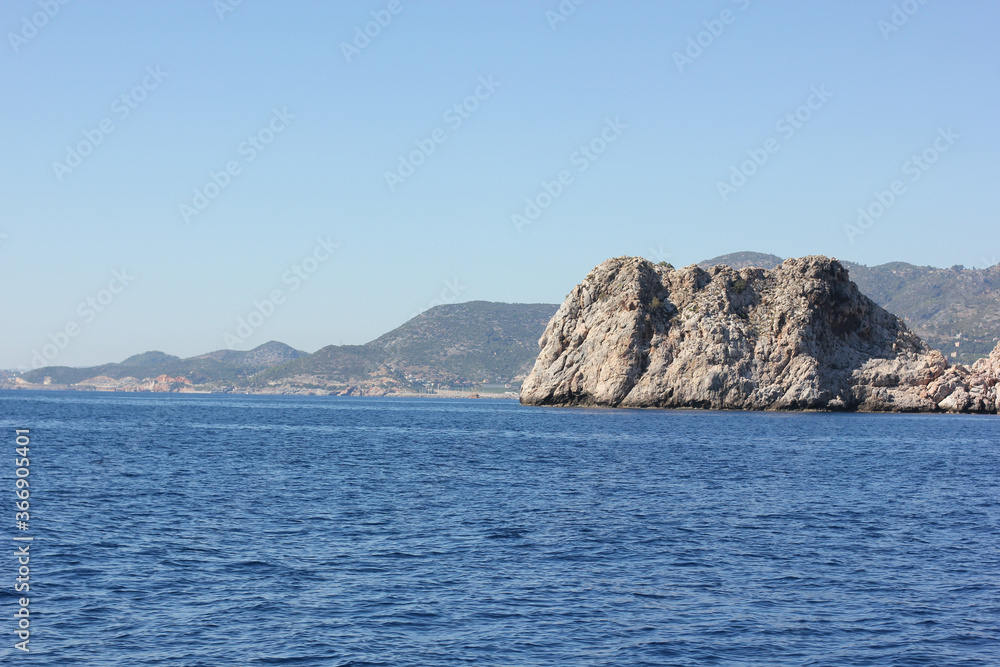 Alanya, TURKEY - August 10, 2013: Travel to Turkey. The waves of the Mediterranean Sea. Water surface. Mountains and hills on the coast of Turkey. Green hills. Alanya, TURKEY - August 10, 2013: Travel to Turkey. The waves of the Mediterranean Sea. Water surface. Mountains and hills on the coast of Turkey. Green hills.