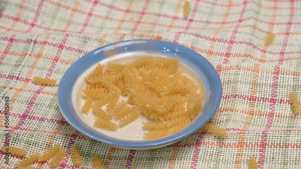 Pasta grains are poured on a white plate. 4K video shooting. Pasta grains are poured on a white plate. 4K video shooting.