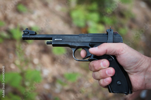 Pistol, small arms close-up in the hands of a policeman.