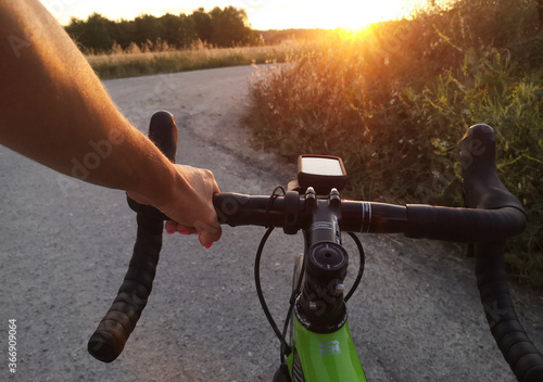 Manubrio di bicicletta e mano di donna al tramonto