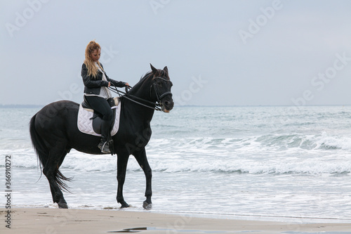young woman on a horse on the beach © emmapeel34
