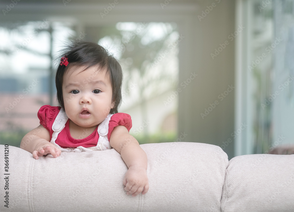 Closeup cute baby girl on sofa with copy space Closeup cute baby girl on sofa with copy space