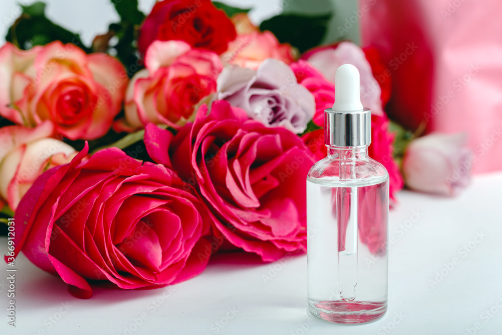 Serum oil on white table floral background. Flower red pink roses natural organic beauty product. Spa, skin care, bath body treatment. Glass cosmetic bottle with rose Mockup. Serum oil on white table floral background. Flower red pink roses natural organic beauty product. Spa, skin care, bath body treatment. Glass cosmetic bottle with rose Mockup.