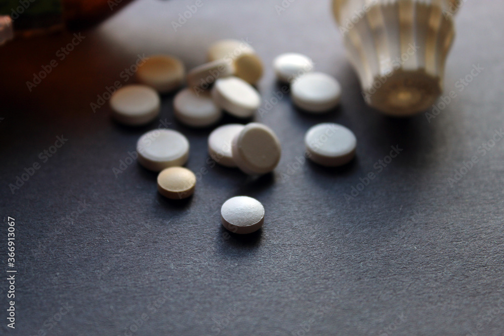 Tablets, pills, medicines and containers display together as medical and pharmacy theme background, selective focus. Tablets, pills, medicines and containers display together as medical and pharmacy theme background, selective focus.