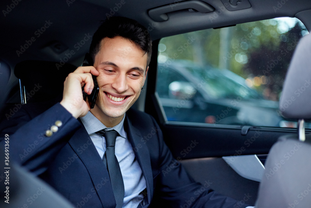 Business executive talking on mobile phone while traveling in car Business executive talking on mobile phone while traveling in car