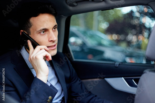 Business executive talking on mobile phone while traveling in car © JoseIMartin