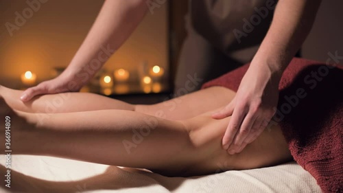 Wallpaper Mural Close-up professional massage of the female hip in the dark room of the spa salon against the background of burning candles. The concept of hip muscle health Torontodigital.ca
