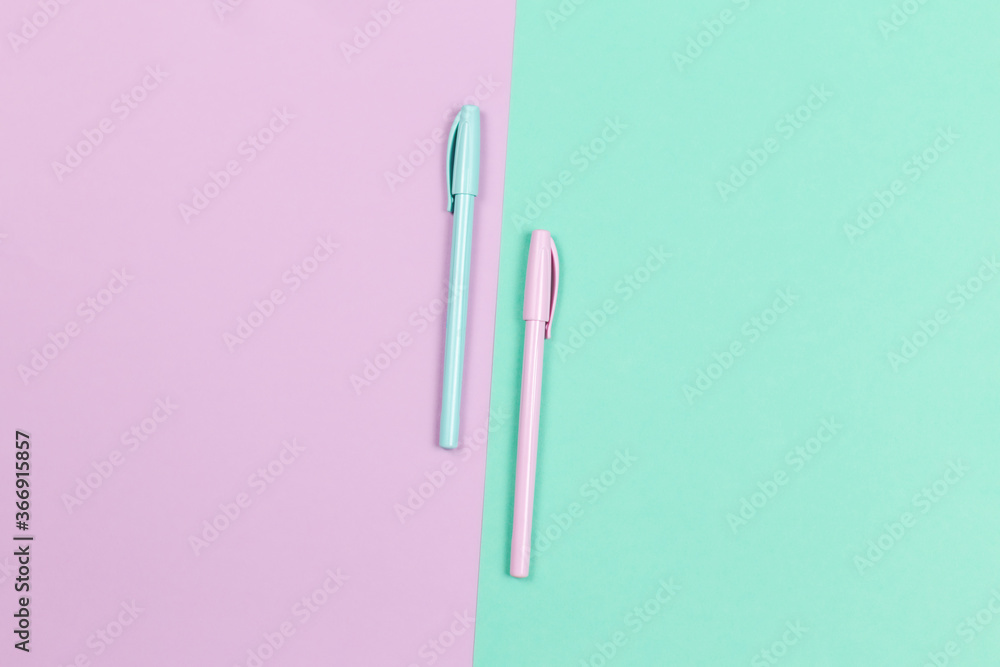 Two pens on a violet and turquoise background. Two pens on a violet and turquoise background.