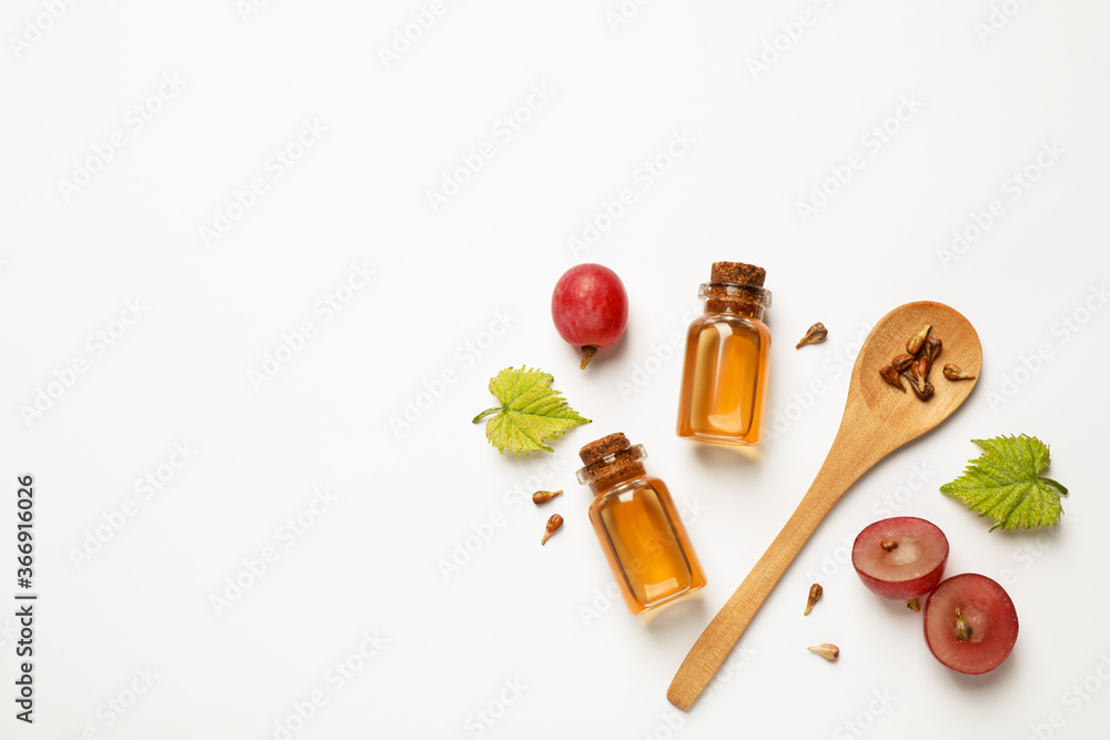 Composition with bottles of natural grape seed oil on white background, top view. Organic cosmetic Composition with bottles of natural grape seed oil on white background, top view. Organic cosmetic