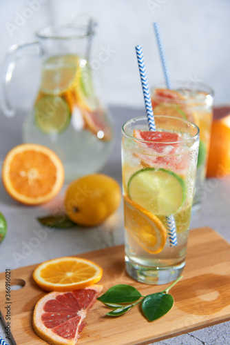 Health care, fitness, healthy nutrition diet concept. Fresh cool homemade citrus infused detox water with grapefruit, orange, lemon and lime and ice in a jug and glasses for spring summer days.