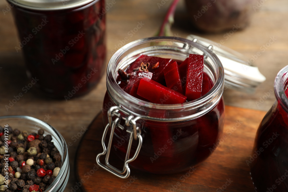 Delicious pickled beets and spices on wooden table, closeup