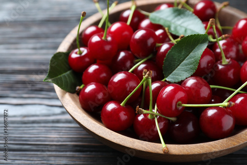 Delicious ripe sweet cherries on dark wooden table, closeup
