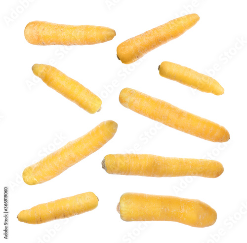 Fresh yellow carrots falling on white background