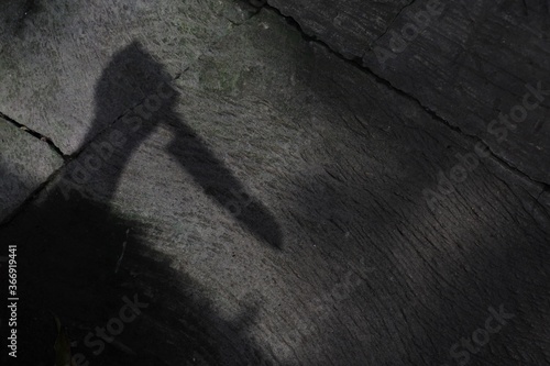 High angle shot of a shadow of human hand holding a knife- murder concept photo