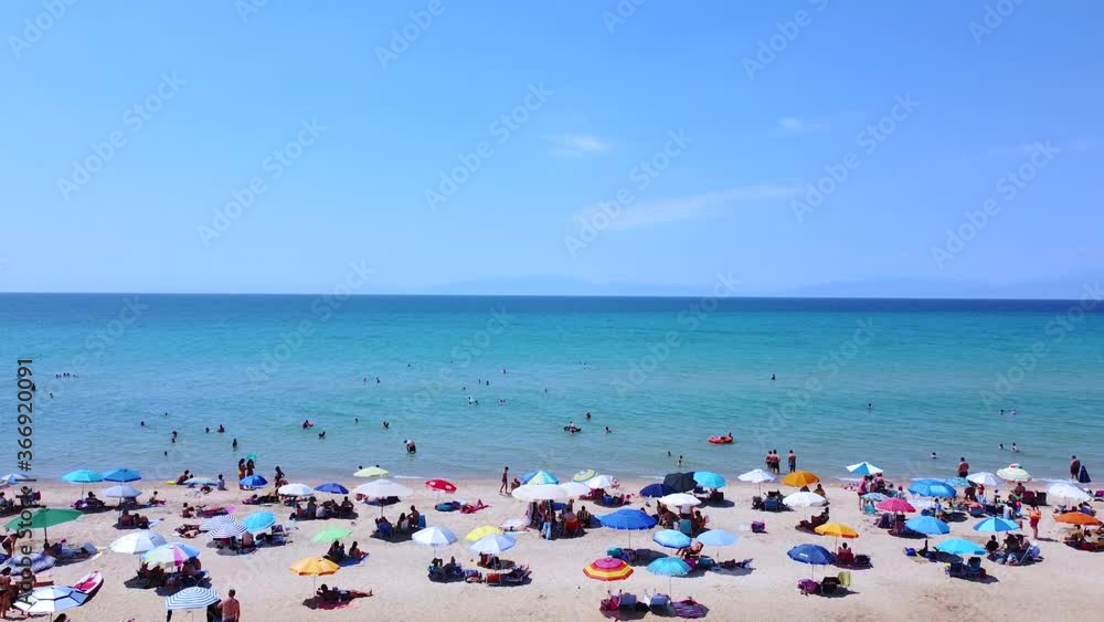 Sunny tourists weekend day on the beach. Busy day on the beach with people enjoying in sun and sea. Aerial view Sunny tourists weekend day on the beach. Busy day on the beach with people enjoying in sun and sea. Aerial view