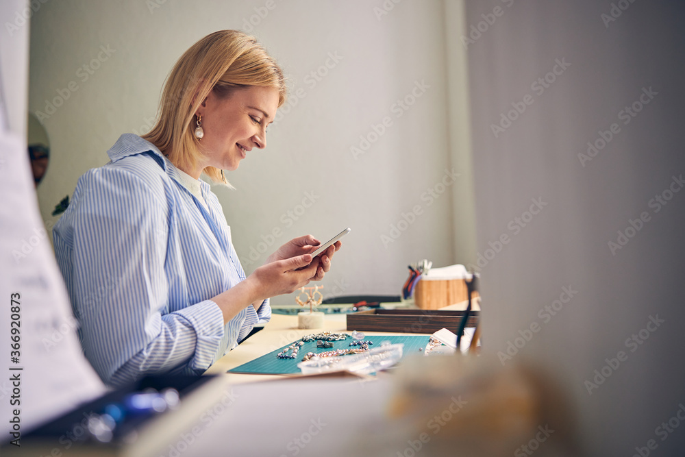 Positive woman keeping eyes on smartphone screen Positive woman keeping eyes on smartphone screen