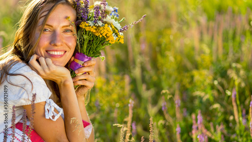 Beautiful woman with wildflower over natural background