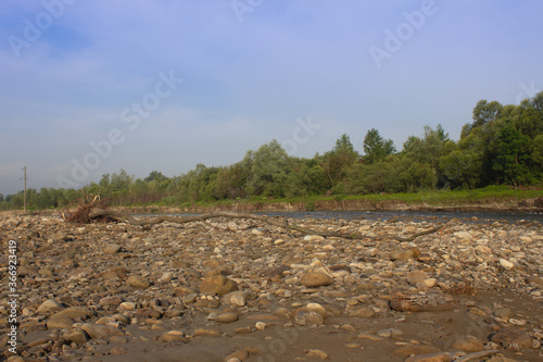 
landscape of a mountain river with stones on the shore