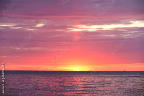 Colorful red sunset sunrise at sea. Water and sky. Minimalism in nature. Dark photo at dusk. Sea landscape. © Ann Stryzhekin