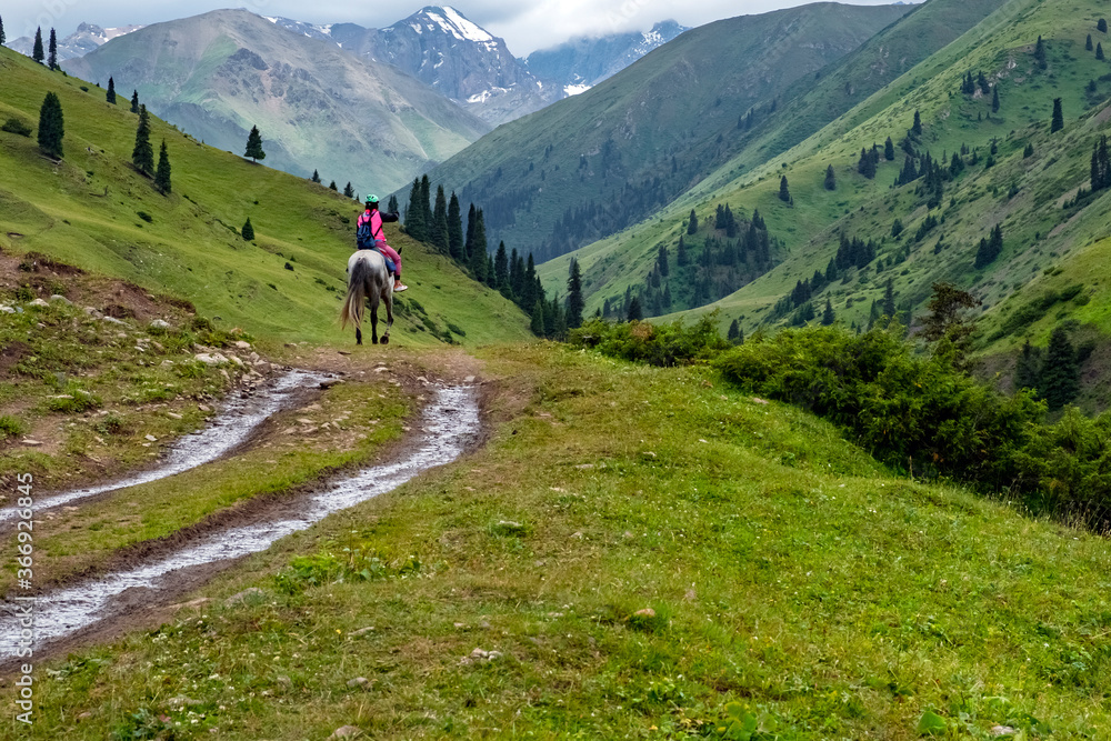 Woman on horse travelling among mountains. Tourism concept. Adventure travel. Concept travel, vacation.