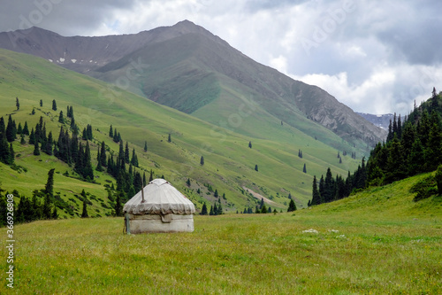 Kazakh traditional yurt in green mountains. Outdoor camping in traditional yourt concept. Travel in Kazakhstan.