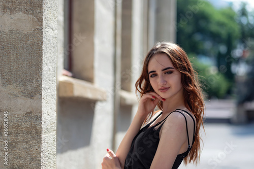 Charming red-haired girl in the Park posing for the camera