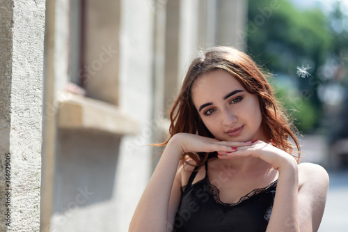 Charming red-haired girl in the Park posing for the camera