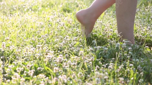 Feet of a woman walking barefoot on the grass