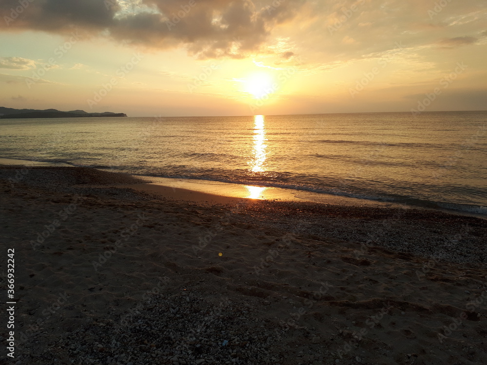 Sunset by the sea view from the beach to the water Sunset by the sea view from the beach to the water