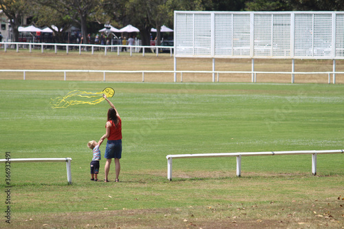Photography Mother and toddler child flying a kite in a sports oval