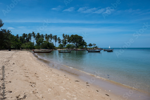 Tranquil beach with boats  on the island of Koh Lanta in southern Thailand.