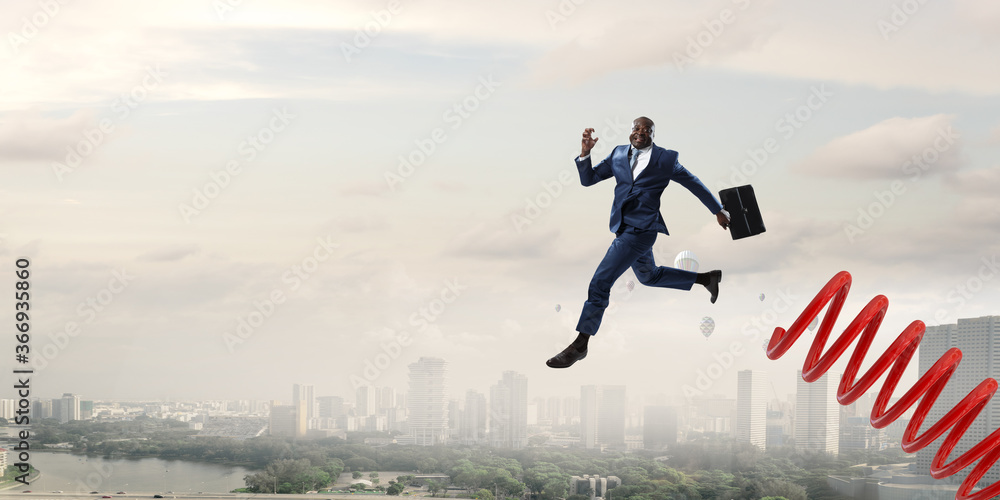 Businessman jumping on springboard . Mixed media Businessman jumping on springboard . Mixed media