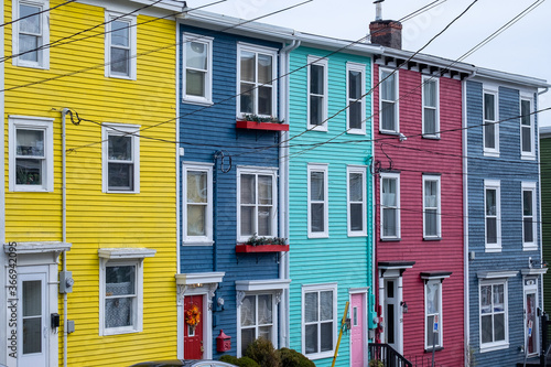 St. John's, NL/Canada - July 2020: A row of colorful adjoining multi-level vintage wooden homes. The houses have three levels with multiple double hung windows and doors. 