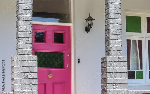 Photography Front veranda of a house with a pink front door and federation window