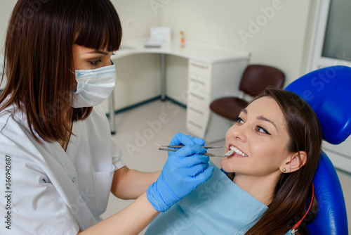 Dentist is holding dental tools and examine the patient teeth in the dentistry