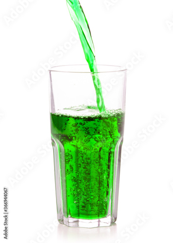 Glass of sweet green carbonated water on white background isolation