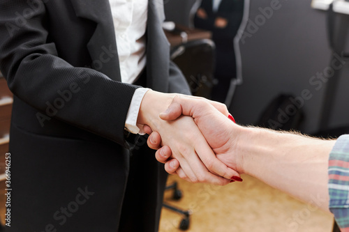 handshake of a woman businessman and a village guy in a shirt