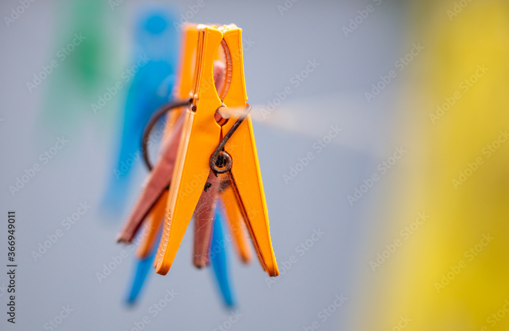A plastic clothespin hangs on a clothesline A plastic clothespin hangs on a clothesline