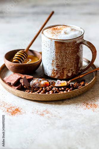 Cappuccino or latte with honey in ceramic dishes. Coffee with milk foam.