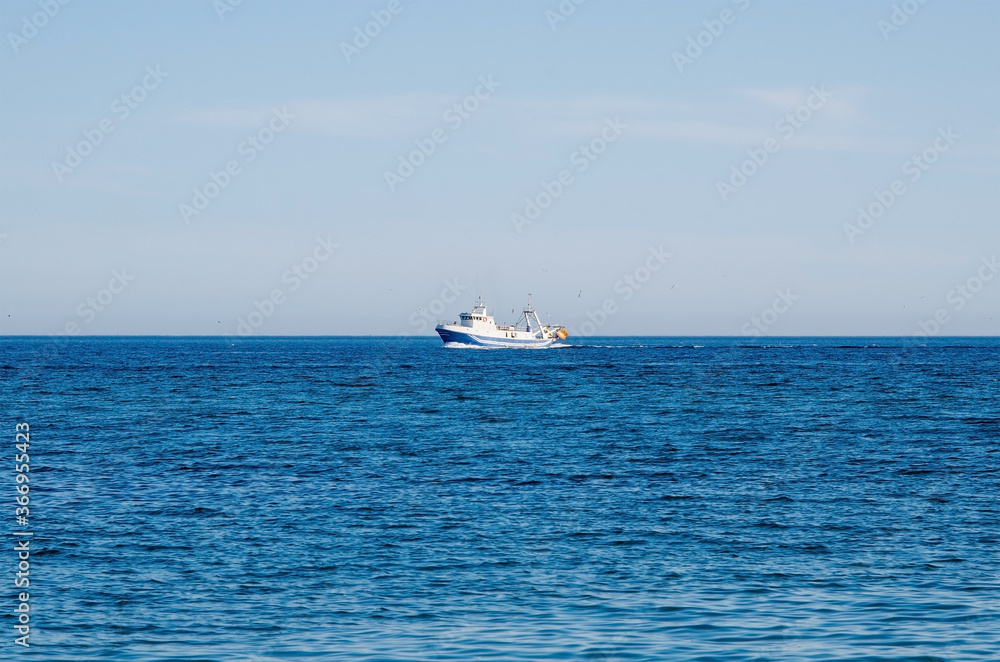 Beautiful Mediterranean sea and fishing boat on the horizon