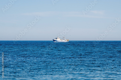 Beautiful Mediterranean sea and fishing boat on the horizon © kazmulka
